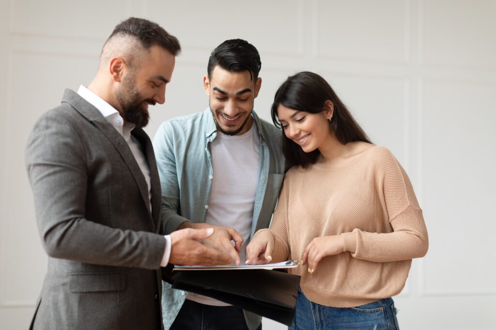 couple buying new apartment house agent showing documents blueprints